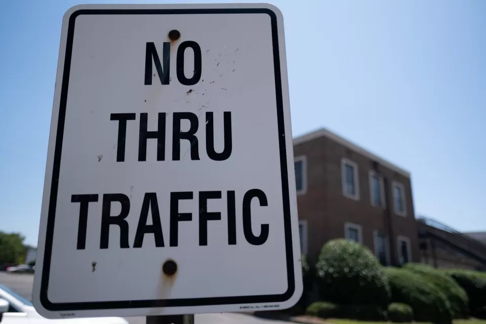 Close-up of white "No Thru Traffic" sign